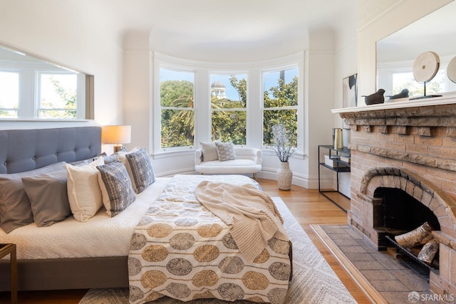 350 Dolores St, San Francisco, CA 94110 - bedroom with light wood-style floors, a fireplace with flush hearth, baseboards, and multiple windows