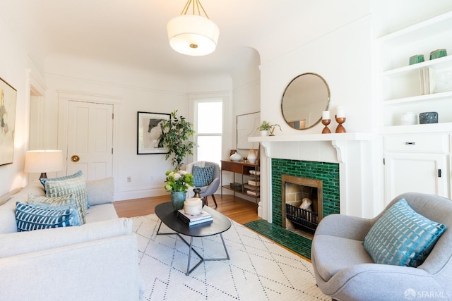350 Dolores St, San Francisco, CA 94110 - living room featuring built in features, baseboards, a tiled fireplace, and wood finished floors