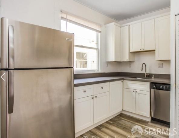 31-33 Harriet St, San Francisco, CA 94103 - kitchen with stainless steel appliances, dark countertops, wood finished floors, and white cabinetry