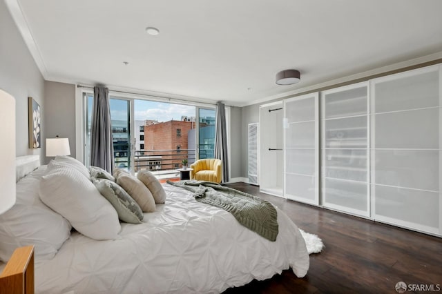 bedroom with crown molding, wood-type flooring, and access to exterior