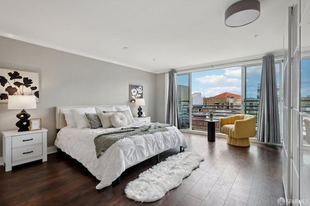 bedroom with dark wood-type flooring, ornamental molding, and a wall of windows