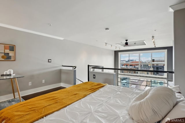 bedroom with hardwood / wood-style flooring and track lighting