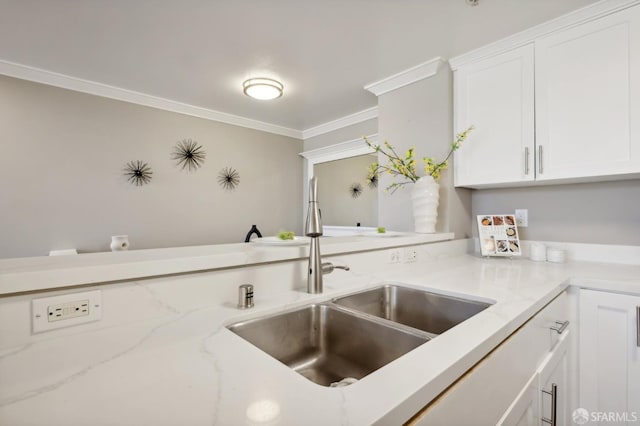 kitchen with ornamental molding, light stone countertops, sink, and white cabinets