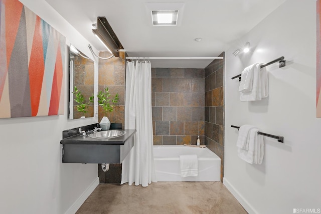 bathroom with sink, concrete floors, and shower / bath combo