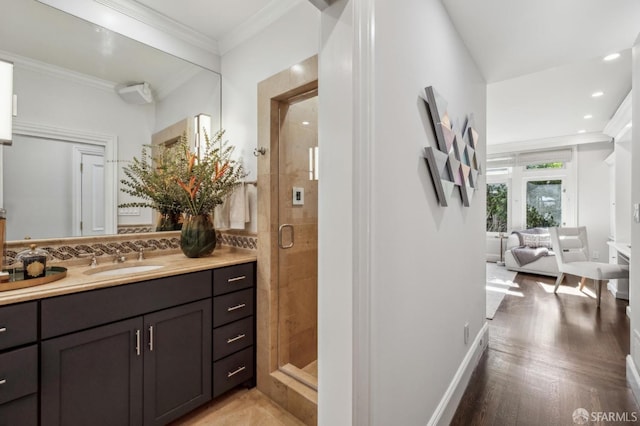 bathroom featuring crown molding, recessed lighting, a stall shower, vanity, and wood finished floors