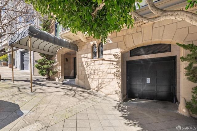 exterior space featuring driveway, stone siding, and an attached garage