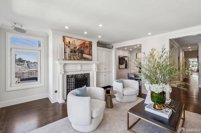 living area featuring a fireplace, recessed lighting, ornamental molding, wood finished floors, and baseboards