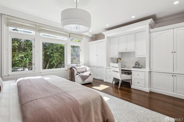 bedroom with dark wood finished floors, ornamental molding, built in desk, multiple closets, and recessed lighting