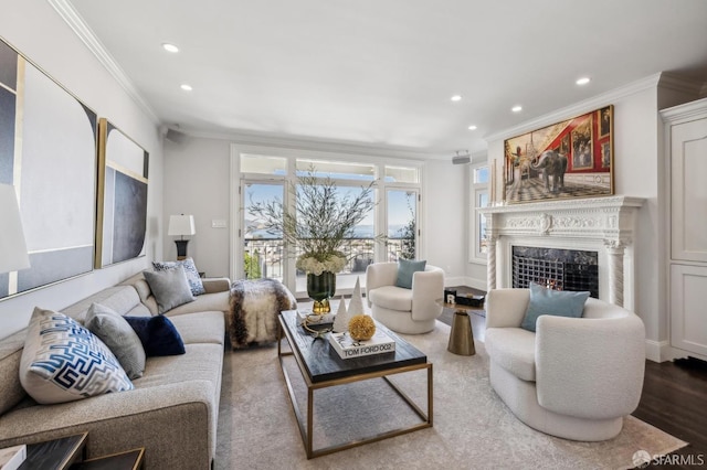 living area with a fireplace, ornamental molding, wood finished floors, and recessed lighting