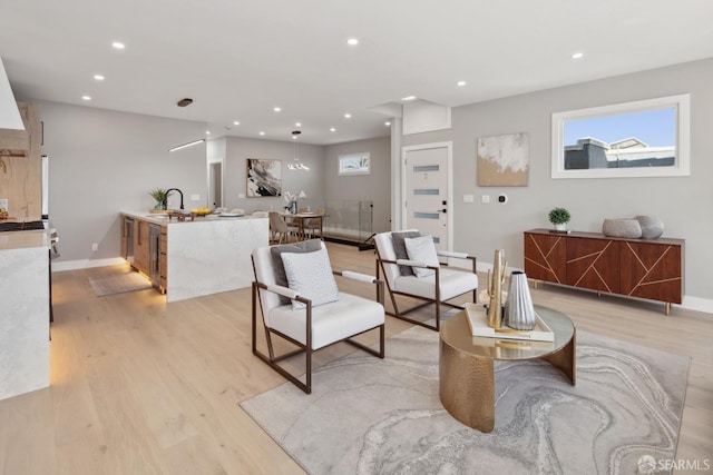 living room featuring sink and light hardwood / wood-style floors