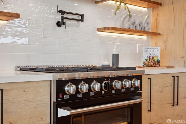 interior details featuring tasteful backsplash and stainless steel stove