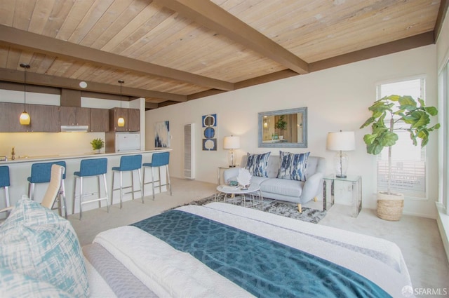 carpeted bedroom with sink, beam ceiling, and wood ceiling