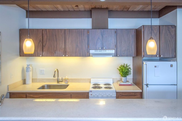 kitchen with sink, hanging light fixtures, and white appliances