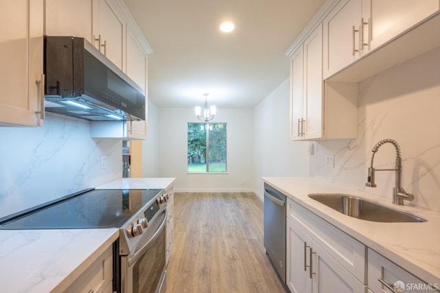 kitchen featuring stainless steel appliances, light wood-style floors, a sink, and white cabinets