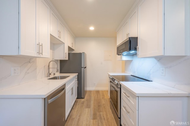 kitchen featuring stainless steel appliances, light wood-style floors, white cabinetry, and a sink