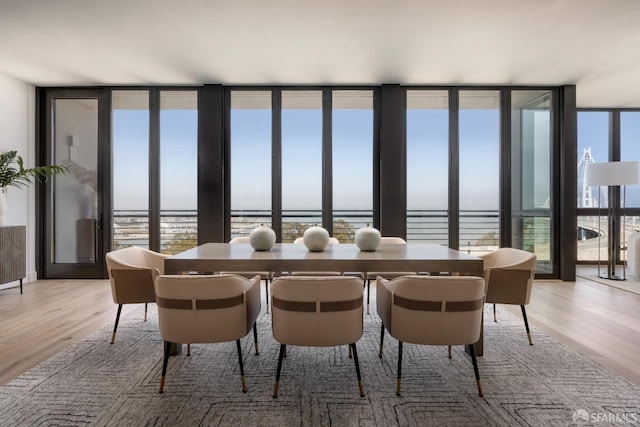 dining space featuring light wood-style flooring and expansive windows