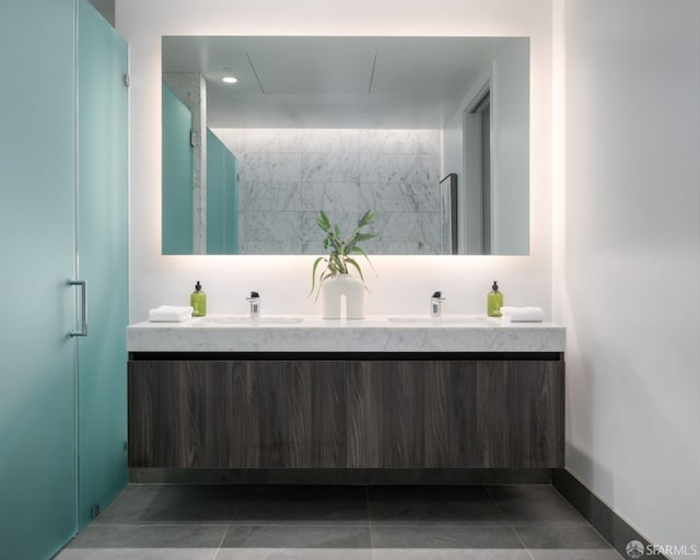 full bathroom with double vanity, tile patterned floors, baseboards, and a sink