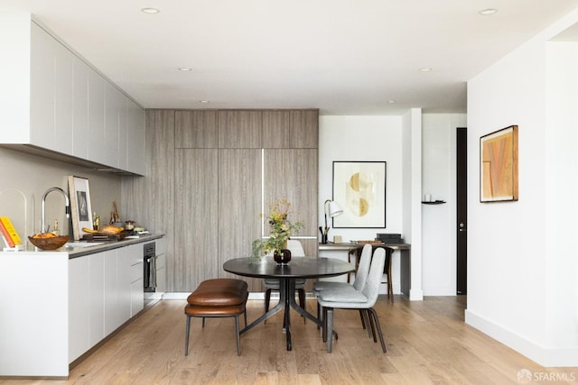 dining room with light wood finished floors, recessed lighting, and baseboards