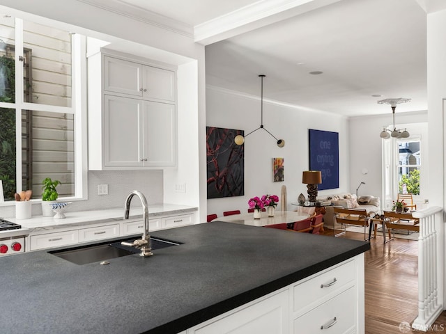 1850 Laguna St, San Francisco, CA 94115 - kitchen with crown molding, a sink, white cabinets, dark countertops, and pendant lighting