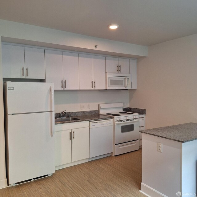 kitchen featuring light wood-type flooring, white appliances, white cabinetry, and sink