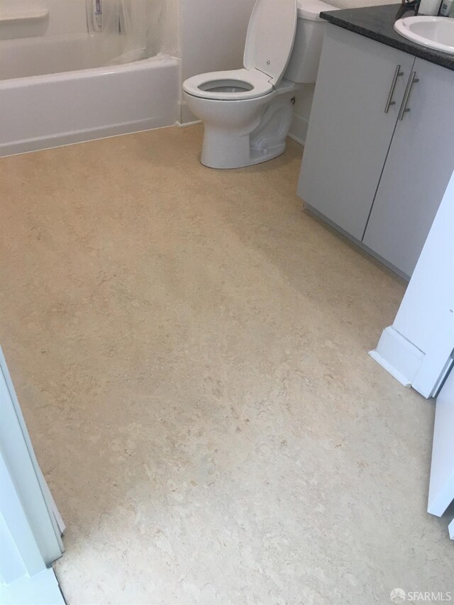 bathroom with a tub, vanity, and toilet