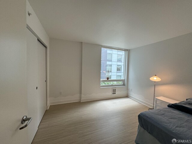 bedroom with a closet and hardwood / wood-style flooring