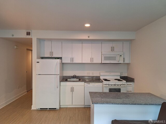 kitchen featuring white cabinets, kitchen peninsula, sink, white appliances, and light wood-type flooring