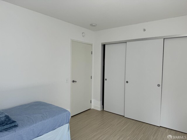 bedroom with a closet and light hardwood / wood-style flooring