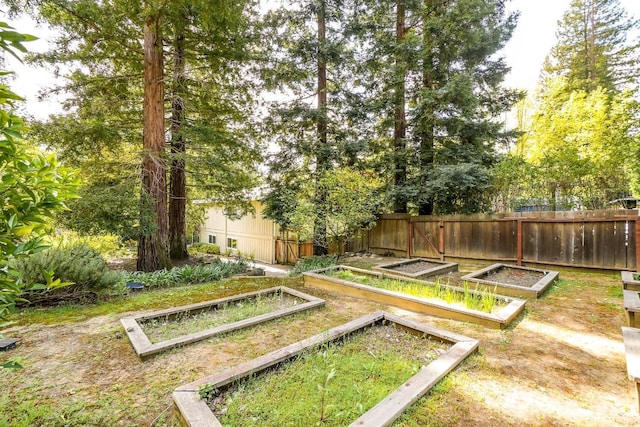 view of property's community with a garden and fence