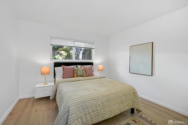 bedroom with wood finished floors and baseboards
