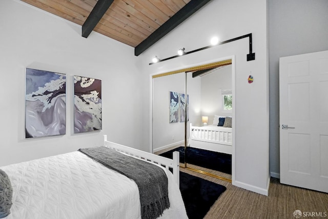 bedroom featuring a closet, baseboards, lofted ceiling with beams, wood ceiling, and carpet flooring