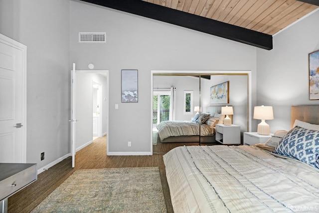 bedroom with baseboards, wood finished floors, vaulted ceiling with beams, and visible vents
