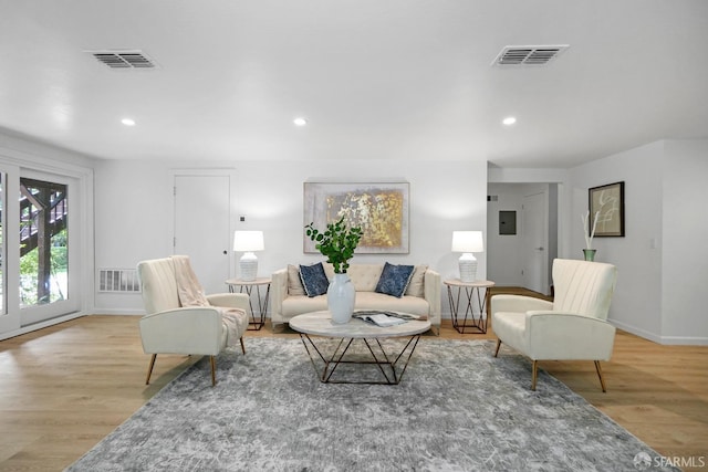 living room with wood finished floors, visible vents, and recessed lighting