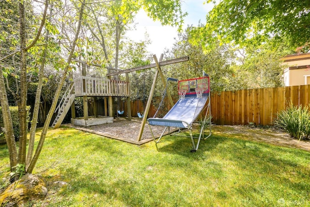 view of jungle gym featuring fence, a lawn, and stairway
