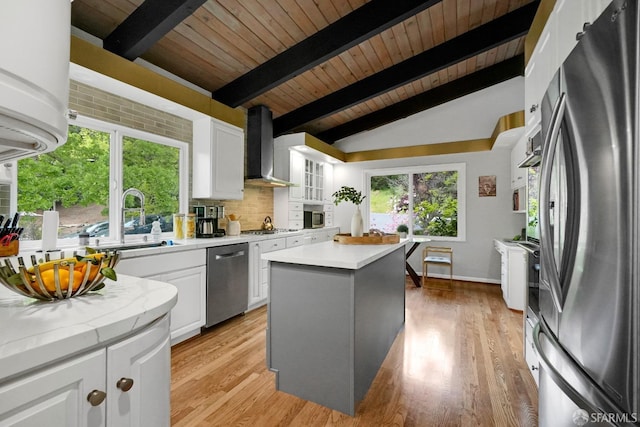 kitchen featuring tasteful backsplash, lofted ceiling with beams, wood ceiling, wall chimney exhaust hood, and appliances with stainless steel finishes