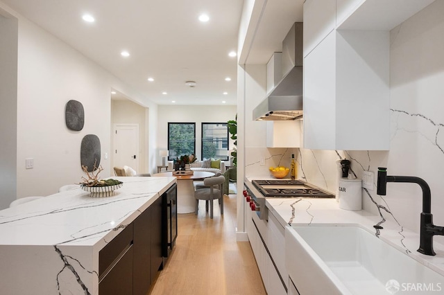 1935-1937 Greenwich St, San Francisco, CA 94123 - kitchen featuring light wood-style flooring, a sink, white cabinets, wall chimney exhaust hood, and modern cabinets