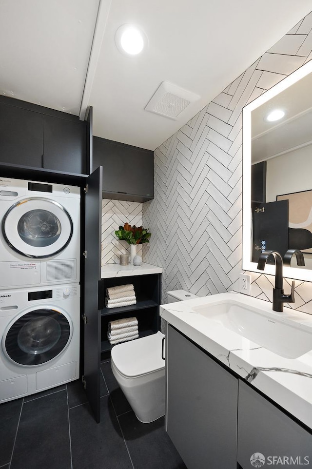 1935-1937 Greenwich St, San Francisco, CA 94123 - bathroom featuring tile patterned flooring, toilet, stacked washer / dryer, vanity, and tile walls