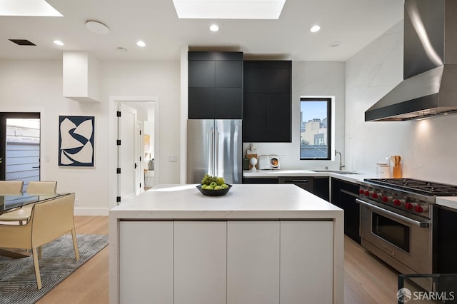 1935-1937 Greenwich St, San Francisco, CA 94123 - kitchen with appliances with stainless steel finishes, a center island, light countertops, and wall chimney range hood