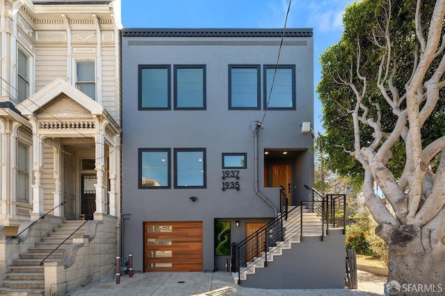 townhome / multi-family property featuring driveway, an attached garage, and stucco siding