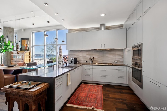 kitchen featuring tasteful backsplash, white cabinetry, sink, and stainless steel appliances