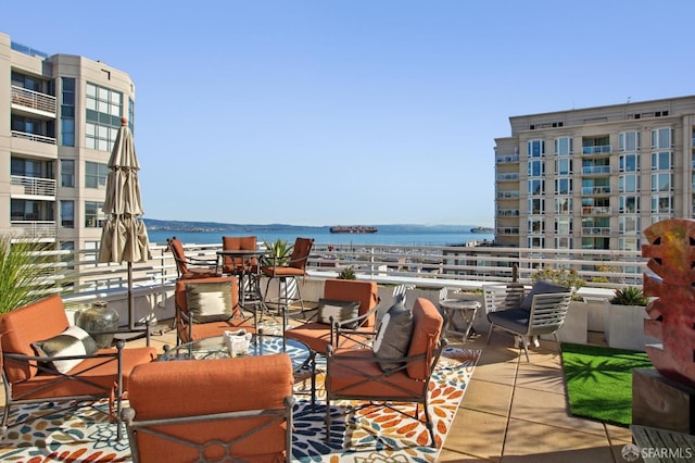 view of patio with a water view and a balcony