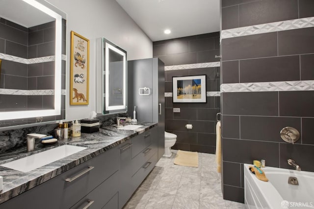 bathroom featuring vanity, tile walls, and toilet