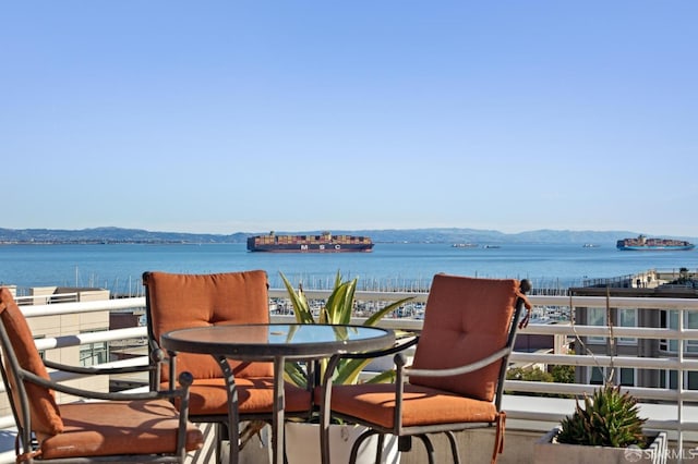 balcony featuring a water and mountain view