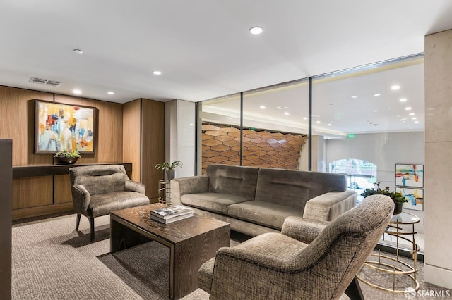 carpeted living room with wood walls