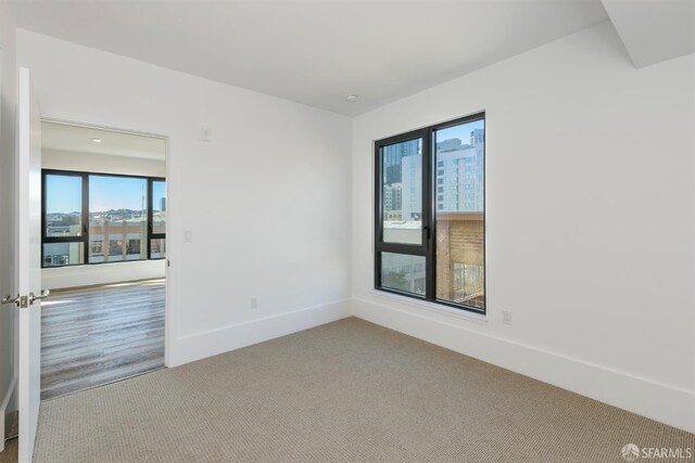 1288 Howard St Unit 418, San Francisco, CA 94103 - unfurnished room featuring plenty of natural light, carpet flooring, and baseboards