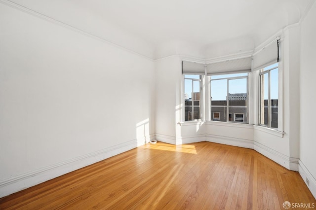 empty room featuring baseboards and wood finished floors