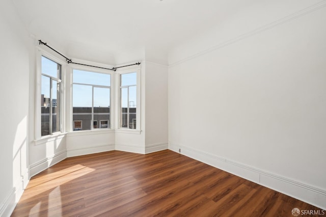 unfurnished room featuring wood finished floors and baseboards