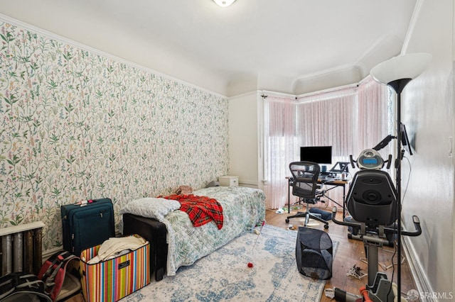 bedroom featuring wallpapered walls and wood finished floors