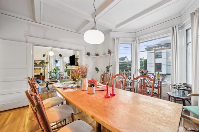 dining room with beam ceiling, coffered ceiling, and wood finished floors