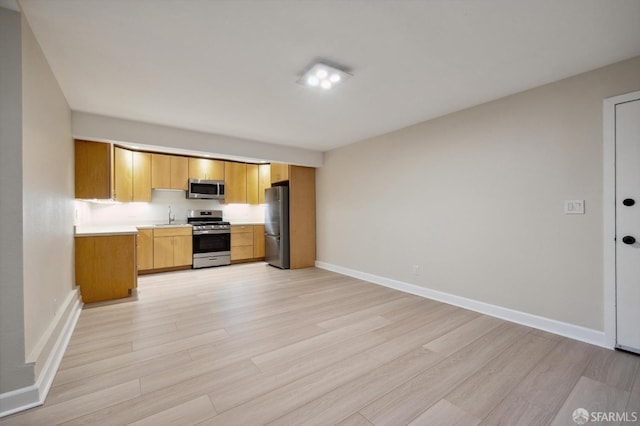 kitchen with stainless steel appliances, light hardwood / wood-style flooring, and sink